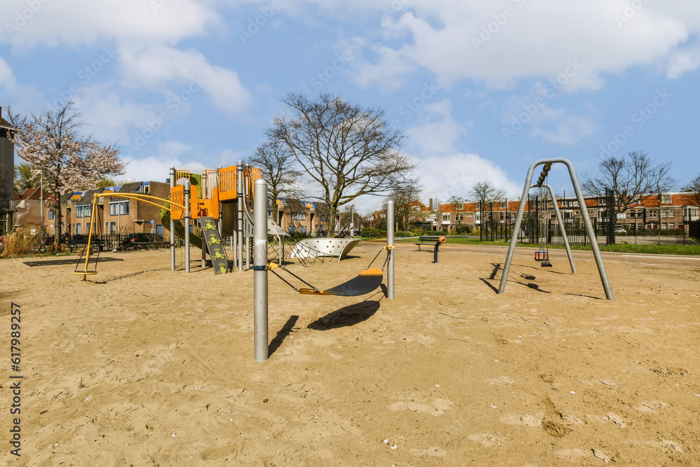 Fototapeta premium an empty playground with swings and slides in the middle part of the photo is taken from the ground to the park