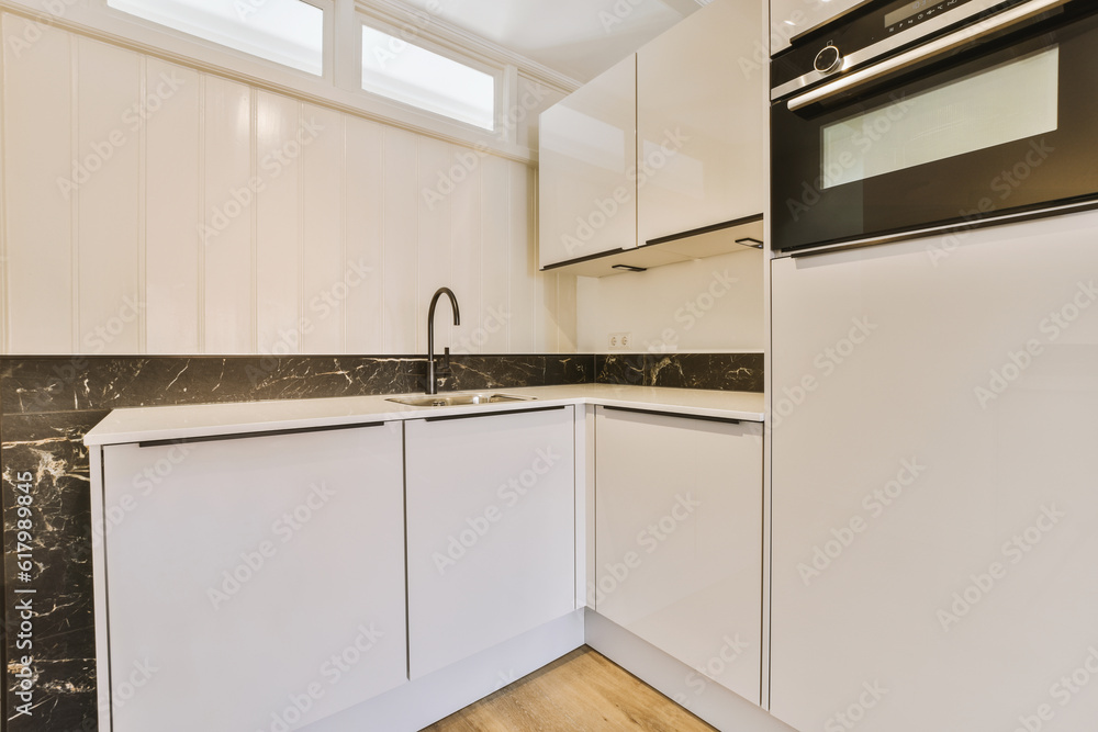 a kitchen with white cabinets and black marble counter tops on the counters in this photo is taken from the inside a kitchen with white cabinets and black marble counter tops on the counters in this photo is taken from the inside