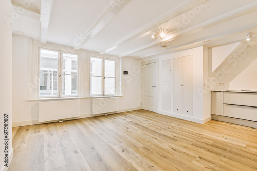Photographie an empty living room with wood floors and white trim on the walls in this photo