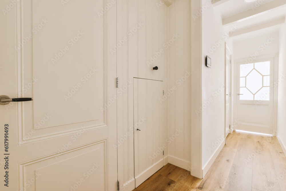 an empty room with white walls and wood flooring in the center of the room there is a door that leads to another room an empty room with white walls and wood flooring in the center of the room there is a door that leads to another room