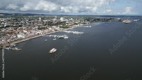 Santarem, Brazil. Aerial drone flight along the coastline above boats on the river.  photo
