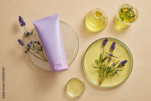 A purple tube placed on podium, displayed with laboratory glassware filled with yellow fluid and purple lavender flowers. Lavender (Lavandula) essential oil can protect your nervous system