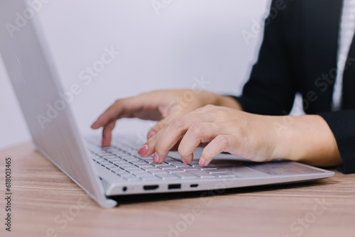 business woman typing working on laptop computer while sitting at home, selective focus on hand