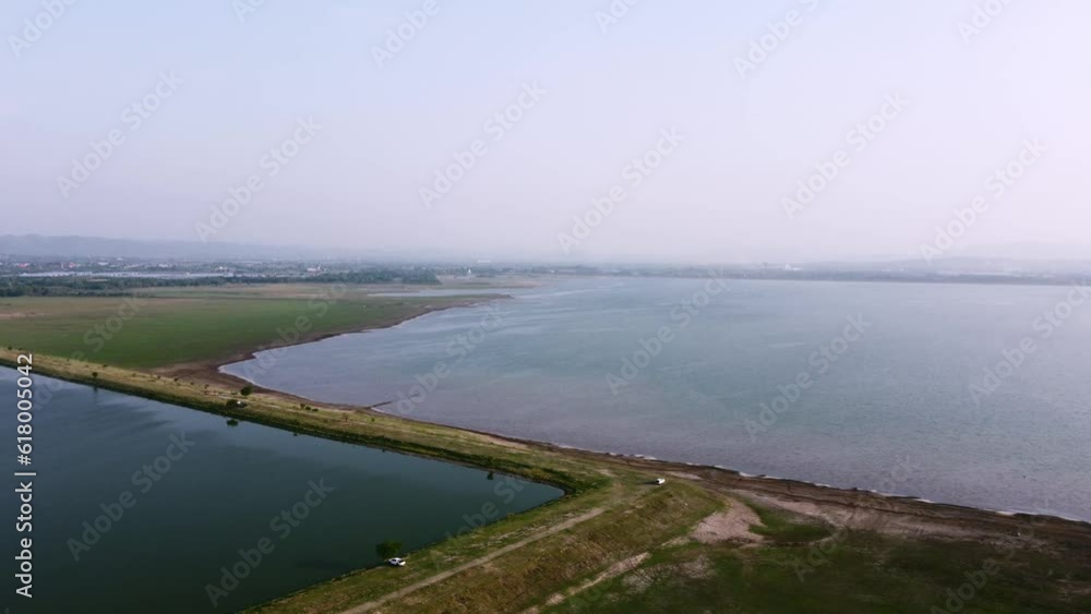 Aerial view shot of Landscape at the end of Pa Sak Jolasid Dam with green grass and water. Destination for camping and rest on holiday and travel. Aerial view shot of Landscape at the end of Pa Sak Jolasid Dam with green grass and water. Destination for camping and rest on holiday and travel.