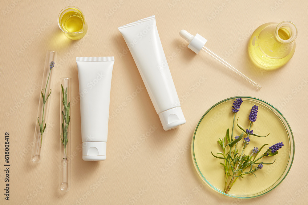 Two empty label tubes in white color put on beige background with laboratory glassware containing Lavender (Lavandula) flowers. Science laboratory research and development concept Two empty label tubes in white color put on beige background with laboratory glassware containing Lavender (Lavandula) flowers. Science laboratory research and development concept