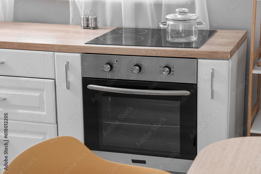 Fototapeta premium Oven with electric stove and cooking pot in kitchen