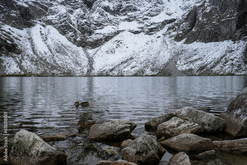 Czarny Staw pod Rysamy or Black Pond lake near the Morskie Oko Snowy Mountain Hut in Polish Tatry mountains, drone view, Zakopane, Poland. Aerial view shot of beautiful green hills and mountains in
