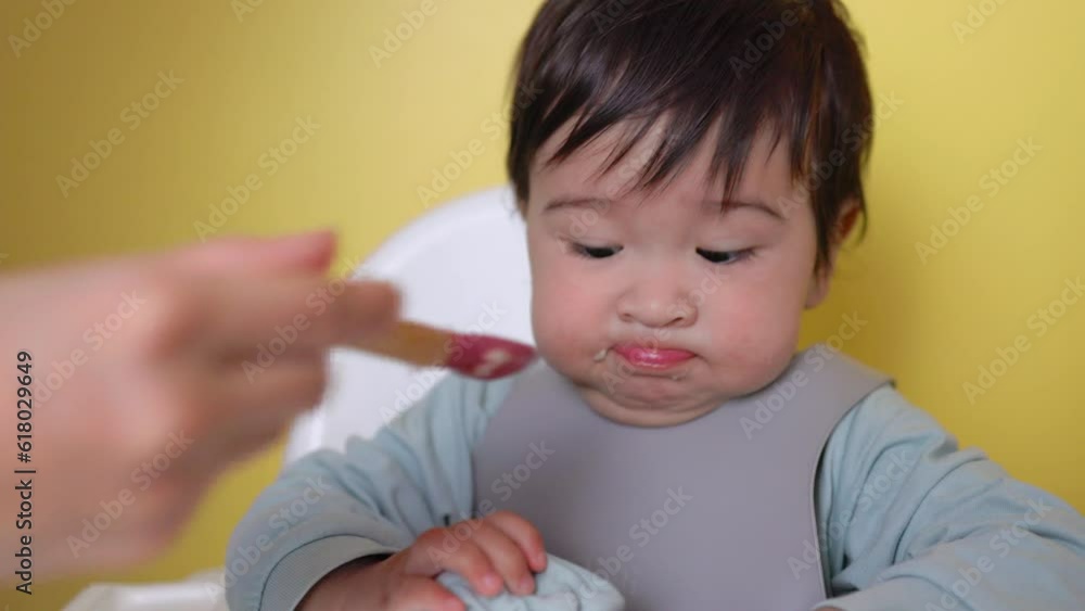 Mom spoon-feeds her baby. Introduction of complementary food, good nutrition, baby food Mom spoon-feeds her baby. Introduction of complementary food, good nutrition, baby food