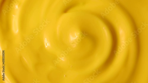 Bright yellow homemade cheese sauce circle rotation close up top view photo