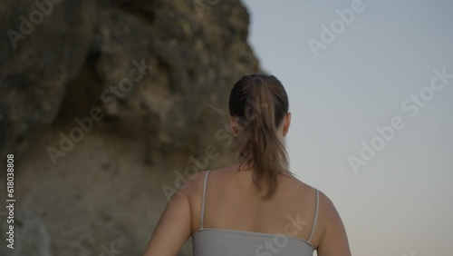 young woman athlete running on beach exercising female runner sprinting training in evening seaside background cliff atsunset photo