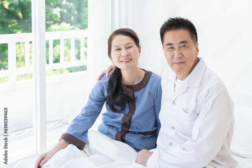 Obraz premium 朝ベッドから起床する高齢者夫婦