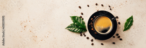 Cup of black coffee, green leaves and beans on light background top view. Cafe and bar, barista art concept. Long banner