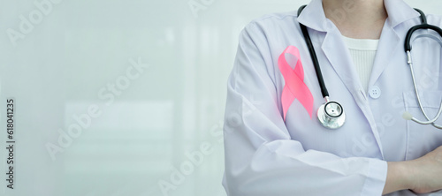 Woman adorning pink ribbon on gown for breast cancer awareness.