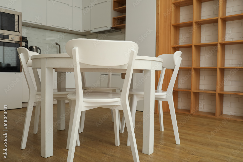 A round, white table with chairs in the kitchen A round, white table with chairs in the kitchen