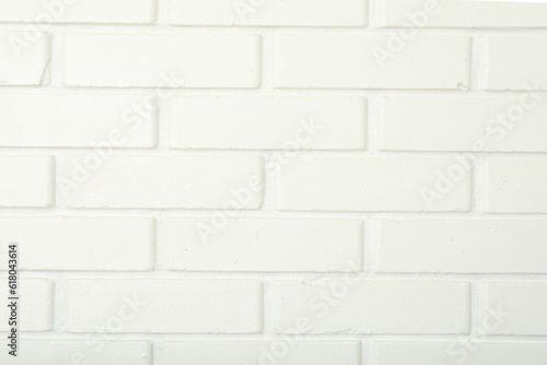 The wall is white with brick texture, close-up