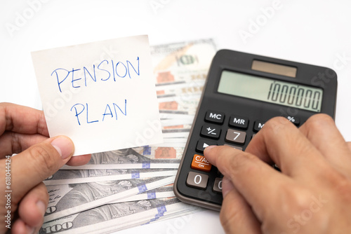 Paper note with phrase Pension Plan, dollar banknotes, calculator. Retirement concept. Retirement saving and pension planning.