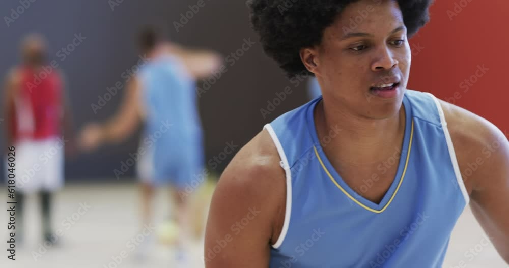 Happy african american male basketball player spinning ball on finger at indoor court, slow motion Happy african american male basketball player spinning ball on finger at indoor court, slow motion