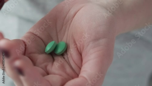 Wallpaper Mural Woman taking green headache pill or painkiller drug in female hand. Taking medicine Torontodigital.ca