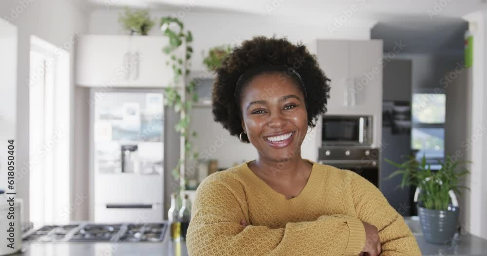 Portrait of happy african american woman smiling in kitchen, in slow motion Portrait of happy african american woman smiling in kitchen, in slow motion