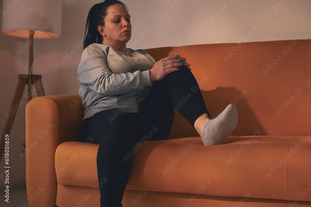 Obraz premium Woman with knee pain, dislocation, numbness, cramp and other joint issues at home.