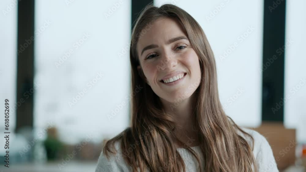 Video of beautiful young woman looking at camera while standing in the living room at home. Video of beautiful young woman looking at camera while standing in the living room at home.