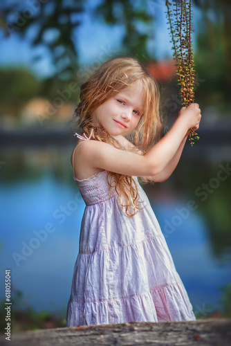 Little girl with long blond hair. Teenager. Tenderness. Sister. Baby in a short summer dress. Summer day. Daughter. On the seashore. Holidays. Baby girl portrait