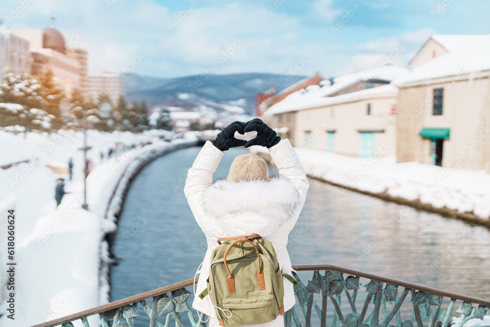 Φωτογραφία Woman tourist Visiting in Otaru, happy Traveler in Sweater sightseeing Otaru canal with Snow in winter season