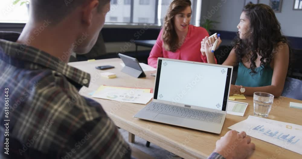Laptop with copy space on screen and diverse colleagues in discussion in casual office, slow motion Laptop with copy space on screen and diverse colleagues in discussion in casual office, slow motion