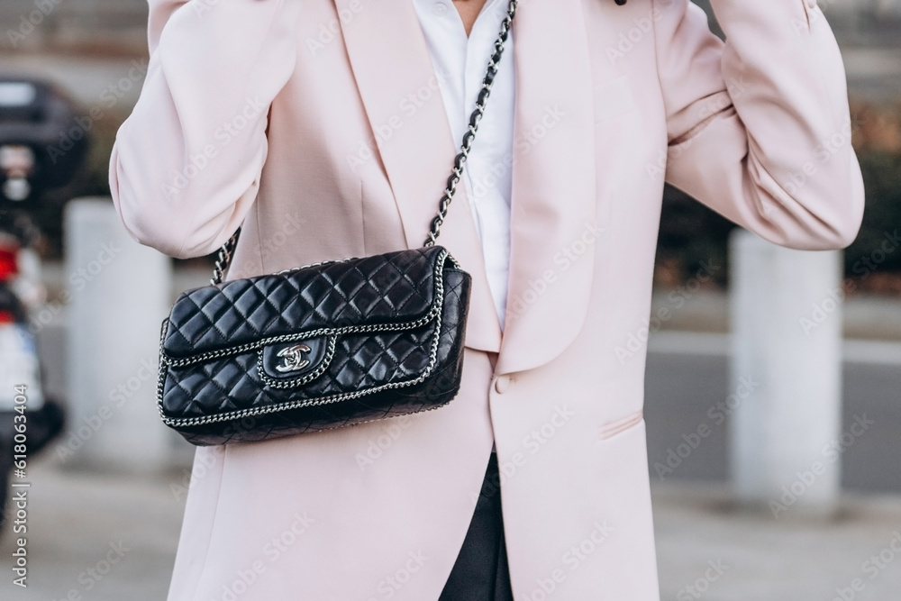 Milan, Italy - January, 13, 2023: woman wears Chanel east west chain around flap  bag, street style details Stock Photo
