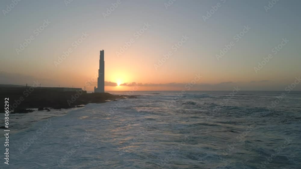 Aerial of the Punta del Hidalgo lighthouse in Spain alongside the foamy sea during the sunset Aerial of the Punta del Hidalgo lighthouse in Spain alongside the foamy sea during the sunset