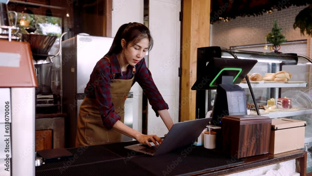 Bakery cafe shop owner working on laptop computers during day in the ...