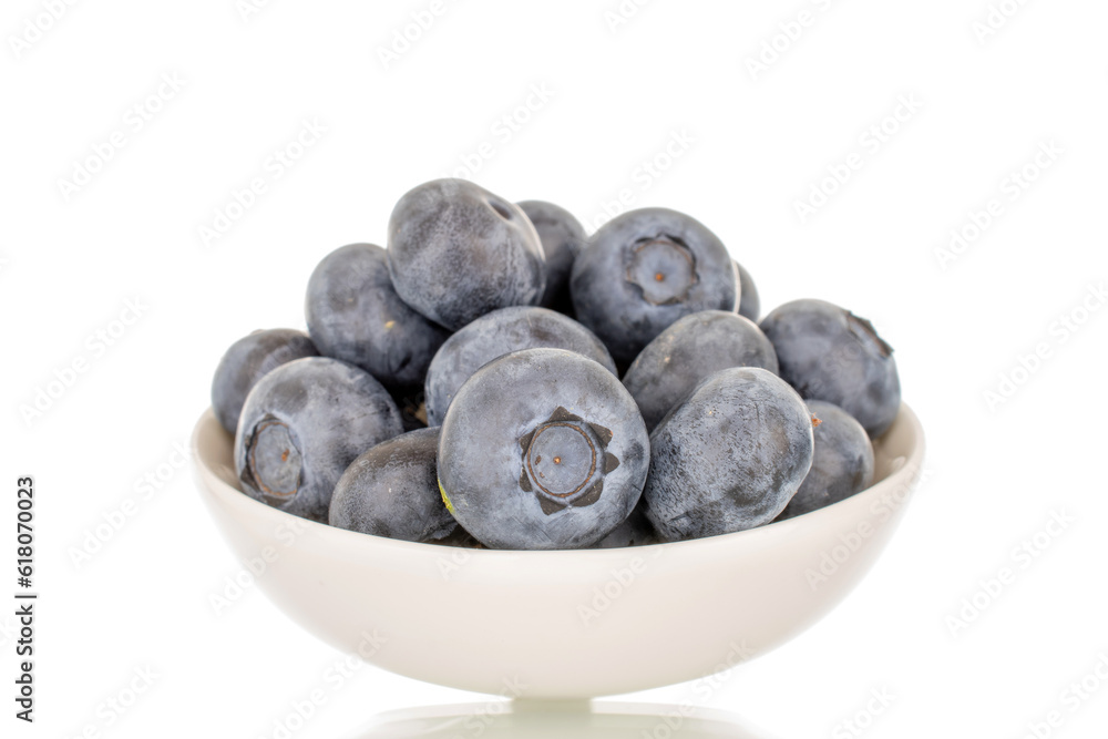 Several sweet blueberries with white saucer, macro, isolated on white background. Several sweet blueberries with white saucer, macro, isolated on white background.