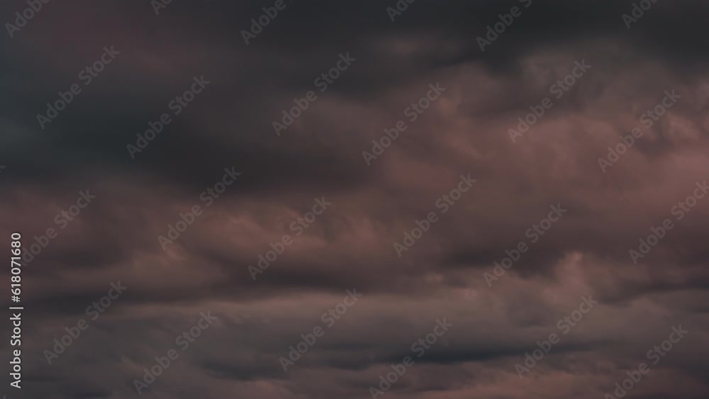 Dark Rain Clouds at Sunset. Time-Lapse. Dark, leaden-toned clouds move fast in the evening sky, backlit by the setting sun Dark Rain Clouds at Sunset. Time-Lapse. Dark, leaden-toned clouds move fast in the evening sky, backlit by the setting sun
