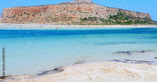Bathers stroll through beautiful crystal clear waters beach with yellow sand at Balos lagoon on Crete, Greece photo