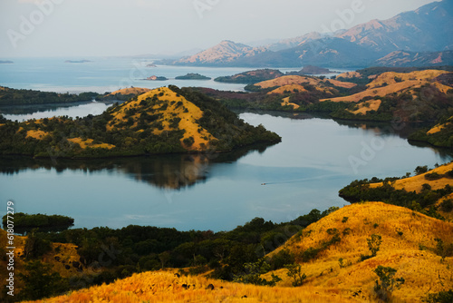 Landscape, view of bays and islands with mountains covered with dry, yellow grass, Flores, Indonesia.