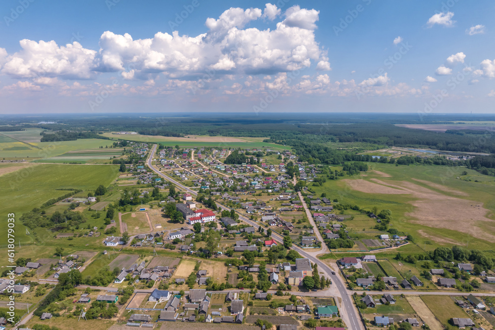 panoramic aerial view of eco village with wooden houses, gravel road, gardens and orchards