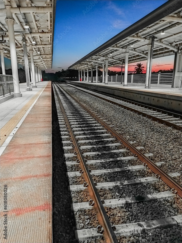 Fototapeta premium a train station with an empty track and a view of the sky