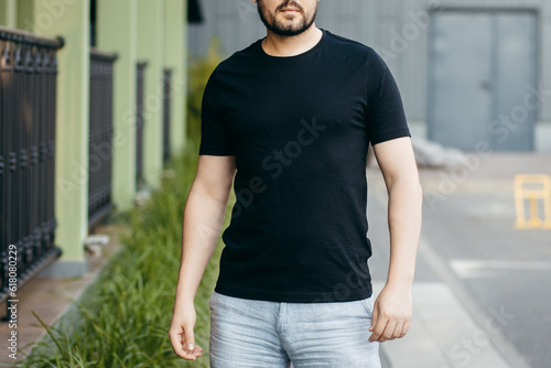 Young stylish bearded man in a black T-shirt and sunglasses. Street photo