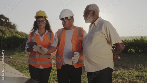 tecnicos mostrando ao agricultor Brasileiro como monitorar a energia solar gerada em sua propriedade rural usando um aplicativo de celular photo