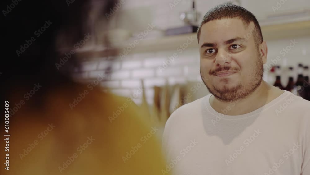 atendente Brasileiro sorrindo conversando com a cliente enquanto ela fecha a sua conta em uma cafeteria no Brasil