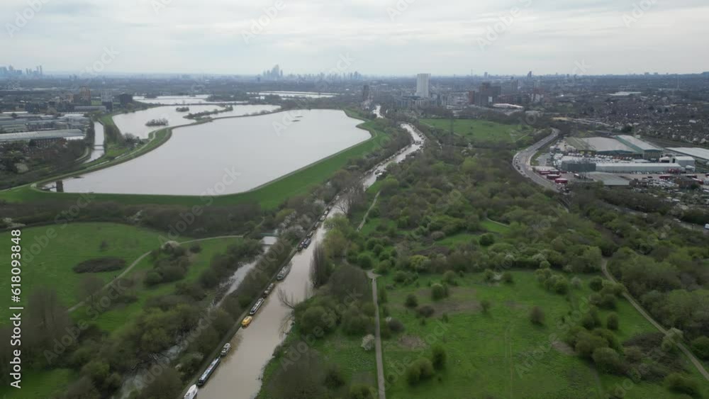 Drone view over a pond and rivers surrounded by trees and fields with a background of a town Drone view over a pond and rivers surrounded by trees and fields with a background of a town