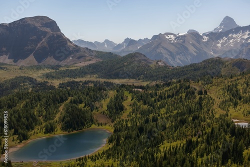 Aerial view of a lake and a picturesque mountain range with majestic peaks in the background © Rob Mccuaig/Wirestock Creators