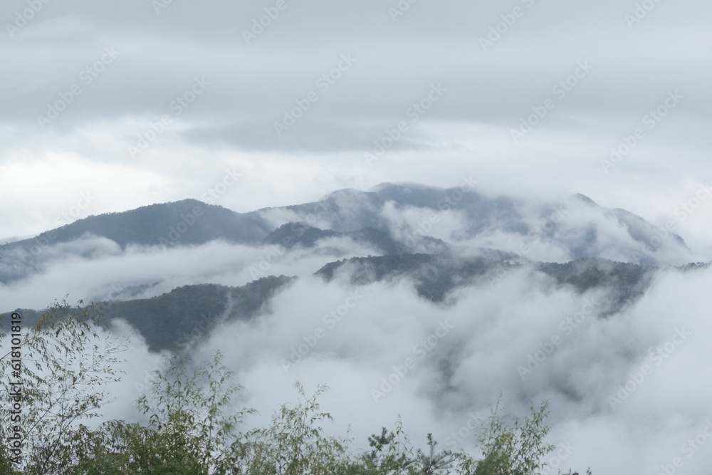 fog over a large mountain covered in low lying clouds,
