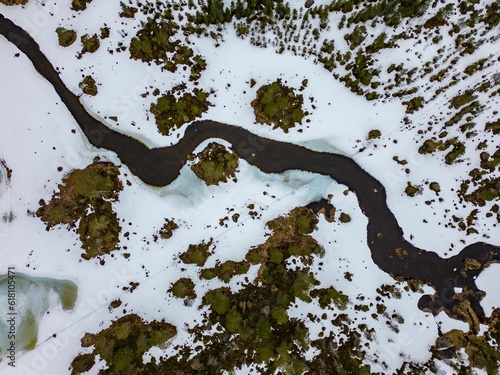 River flowing through a snowy valley with evergreen trees. Trollheimen, Norway. photo