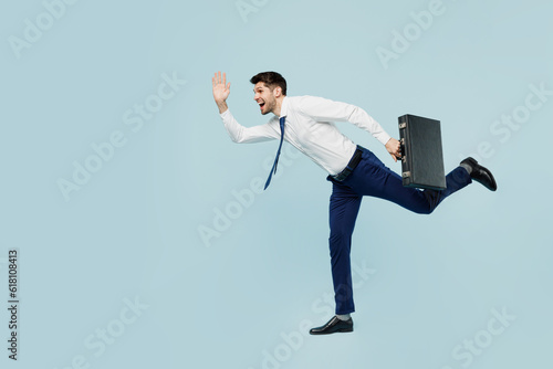 Full body side view young employee IT business man corporate lawyer wear classic formal shirt tie work in office hold inahnd briefcase isolated on plain pastel light blue background studio portrait.