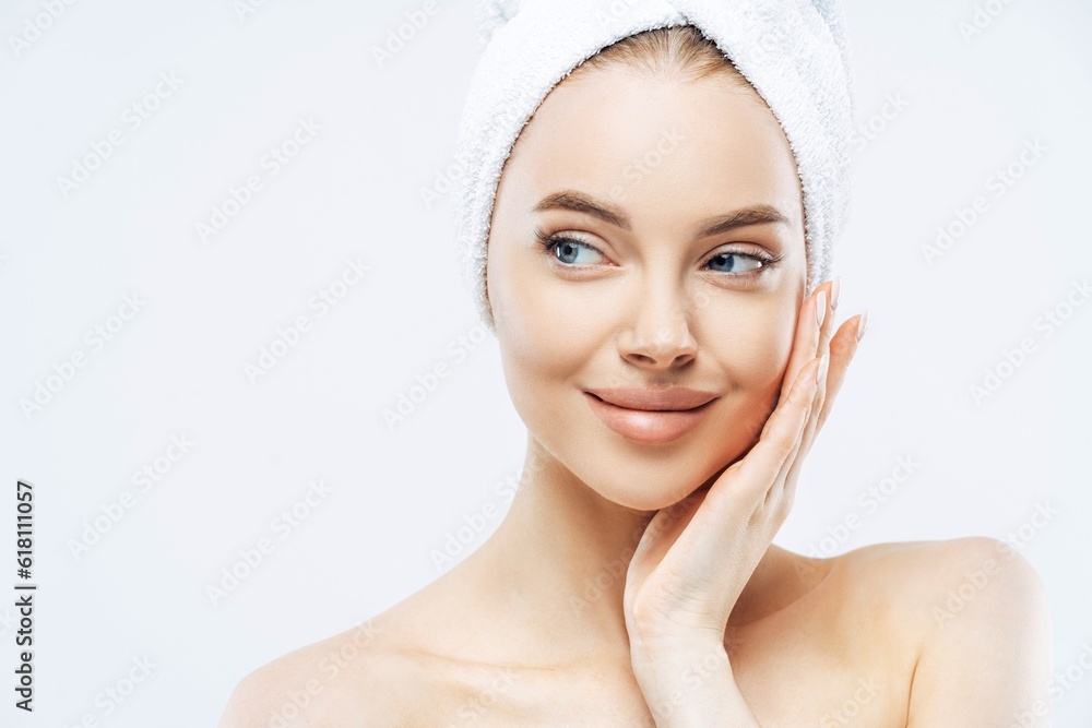 Model with makeup, touches cheek, fresh skin after bath, towel on head, isolated Model with makeup, touches cheek, fresh skin after bath, towel on head, isolated