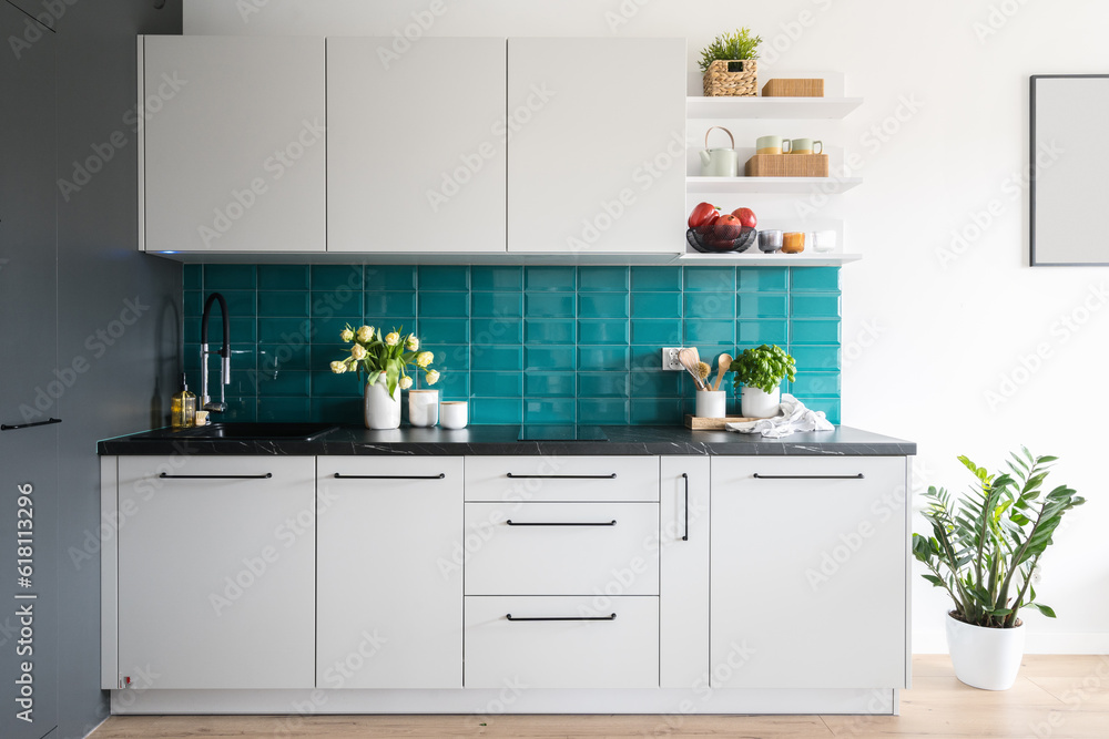 home kitchen with cozy interior, white cupboard and blue tiled wall home kitchen with cozy interior, white cupboard and blue tiled wall