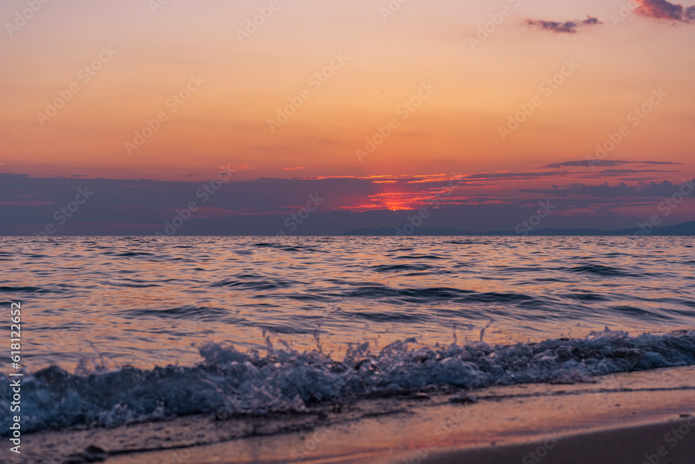 empty beach with the waves and beautiful sunset. blue sky and natural couds. reflection of sun on sandy beach empty beach with the waves and beautiful sunset. blue sky and natural couds. reflection of sun on sandy beach