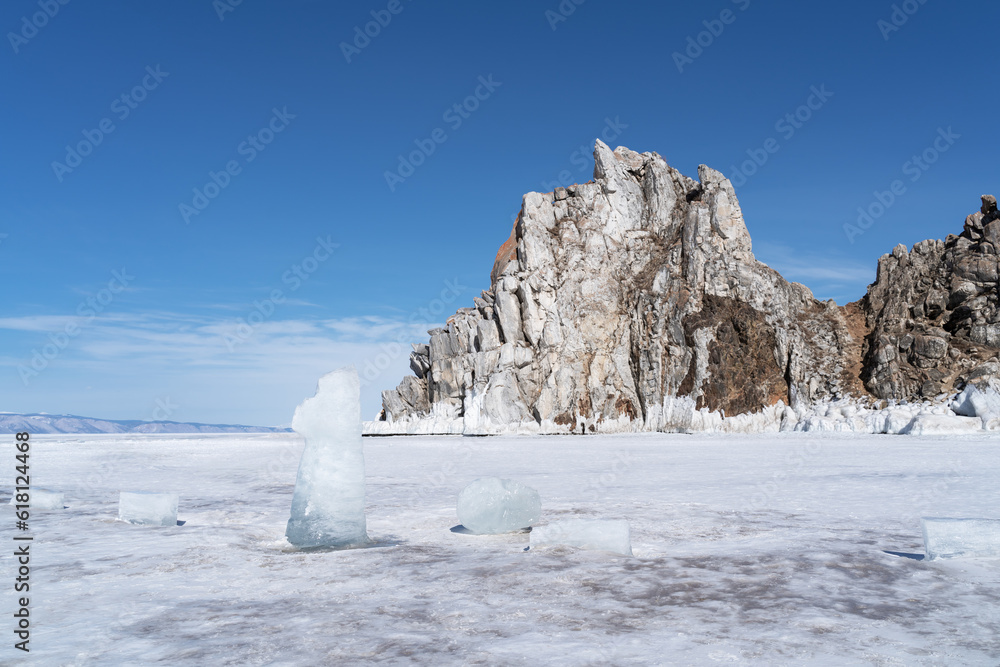Beautiful winter landscape with blue ice cave grotto and frozen clear icicles. Lake Baikal, Russia. Natural winter background with copy space.
