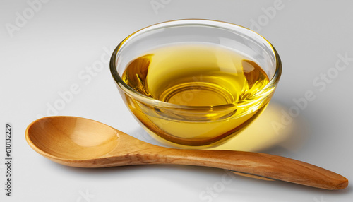 Soybean oil or vegetable cooking oil in glass bowl with wooden spoon isolated on white background with clipping path. photo